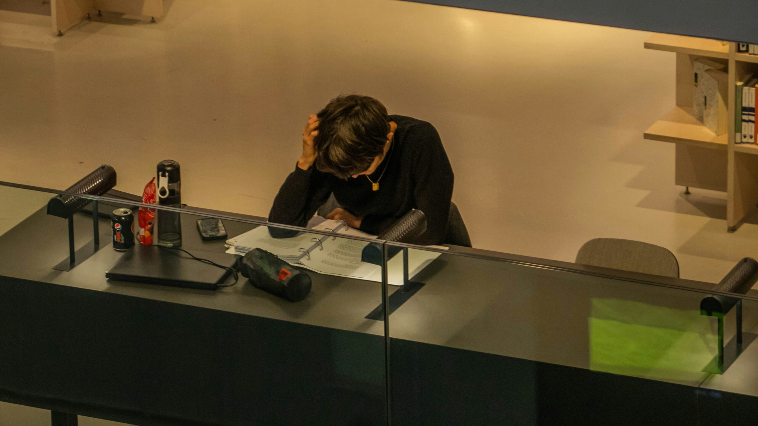 A gamer slumped over their desk after consuming too much caffeine